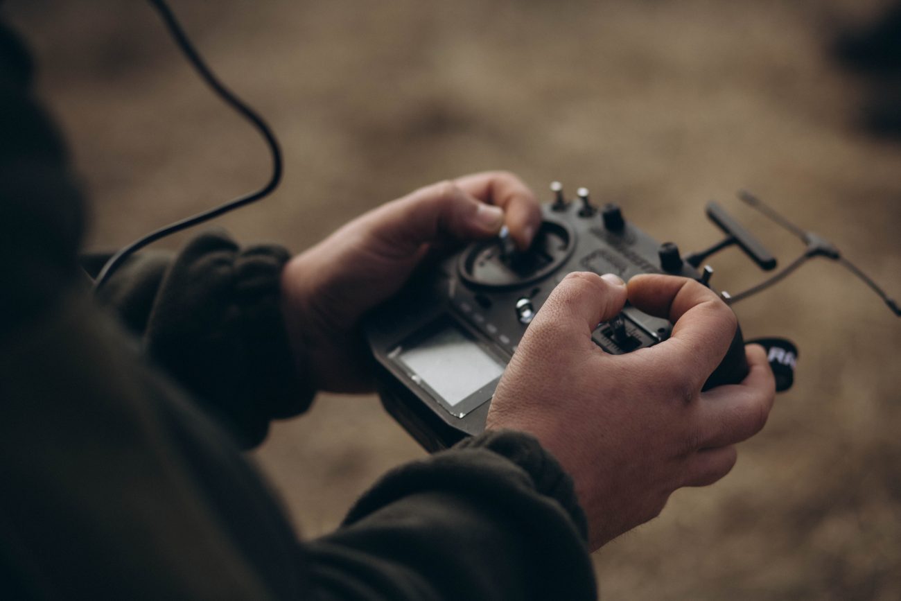 The operator controls the drone using a remote controller.